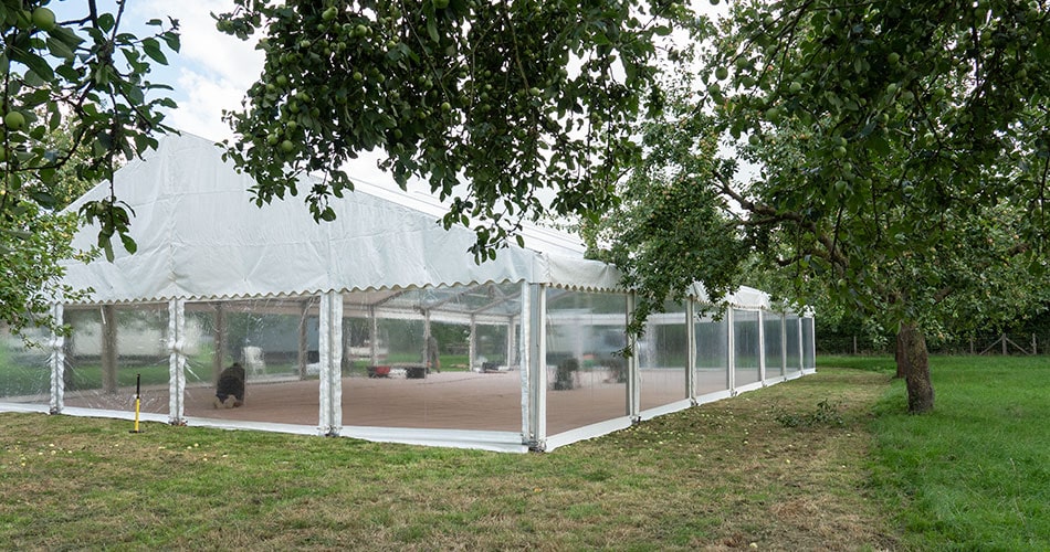 A clearspan marquee being set up in an orchard in Somerset