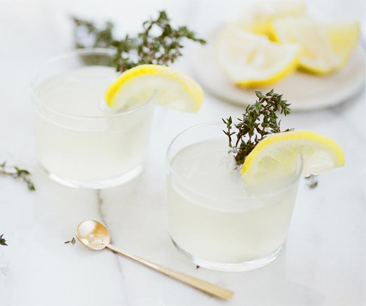 botanical cocktails decorated with lemon and thyme sprig for wedding aperitifs